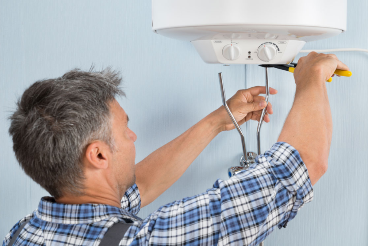 сантехник котел. обслуживание бойлера. мастер чинит водонагреватель. починка бойлера. ремонт бойлеров.